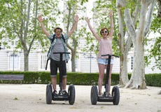 Молодые счастливые туристские пары ехать segway наслаждаясь город путешествуют в парке Мадрида в Испании совместно Стоковое фото RF Молодые счастливые туристские пары ехать segway наслаждаясь город путешествуют в парке Мадрида в Испании совместно Стоковое фото RF