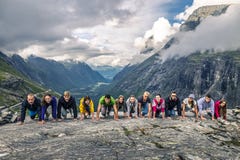 Молодые люди имеет потеху на верхней части горы, Trollstigen, стоковое изображение Молодые люди имеет потеху на верхней части горы, Trollstigen, стоковое изображение