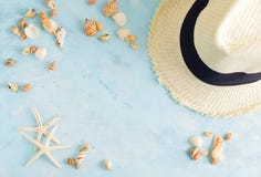 Модель-макет летних каникулов: соломенная шляпа, seashells и белые морские звёзды на голубой предпосылке Перемещение, концепция п стоковое изображение rf Модель-макет летних каникулов: соломенная шляпа, seashells и белые морские звёзды на голубой предпосылке Перемещение, концепция п стоковое изображение rf