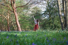 Модная дама представляя в английской древесине с bluebells и деревьями стоковые изображения Модная дама представляя в английской древесине с bluebells и деревьями стоковые изображения