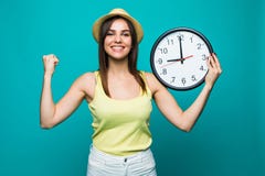 Молодая excited женщина держа часы показывая почти 9 с счастливыми эмоциями победы на зеленой предпосылке стоковые изображения rf Молодая excited женщина держа часы показывая почти 9 с счастливыми эмоциями победы на зеленой предпосылке стоковые изображения rf