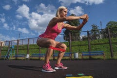 Молодая sporty женщина делая тренировки с круглой резинкой внешней стоковое фото Молодая sporty женщина делая тренировки с круглой резинкой внешней стоковое фото