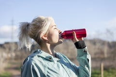 Молодая белокурая питьевая вода девушки во время jogging утра стоковые изображения Молодая белокурая питьевая вода девушки во время jogging утра стоковые изображения
