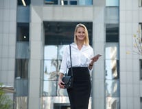 Молодая бизнес-леди перед офисным зданием используя ее сотовый телефон стоковые фото Молодая бизнес-леди перед офисным зданием используя ее сотовый телефон стоковые фото