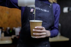 Молодая девушка barista лить стекло капучино стоковое фото rf Молодая девушка barista лить стекло капучино стоковое фото rf
