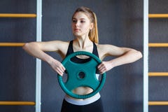 Молодая девушка спортсменов делает тренировки на спортзале изолированная принципиальной схемой белизна спорта стоковые изображения Молодая девушка спортсменов делает тренировки на спортзале изолированная принципиальной схемой белизна спорта стоковые изображения