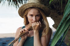 Молодая женщина в букете владением соломенной шляпы высушенных wildflowers стоковые фотографии rf Молодая женщина в букете владением соломенной шляпы высушенных wildflowers стоковые фотографии rf