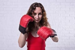 Молодая женщина в красных кладя в коробку перчатках на белой предпосылке кирпича стоковое изображение Молодая женщина в красных кладя в коробку перчатках на белой предпосылке кирпича стоковое изображение