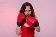 Молодая женщина в красных кладя в коробку перчатках на розовой предпосылке стоковые изображения rf Молодая женщина в красных кладя в коробку перчатках на розовой предпосылке стоковые изображения rf