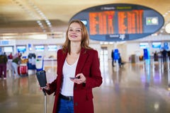Молодая женщина в международном аэропорте стоковая фотография Молодая женщина в международном аэропорте стоковая фотография
