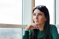 Молодая женщина в превидении смотрит вне огромное окно к улице стоковое фото rf Молодая женщина в превидении смотрит вне огромное окно к улице стоковое фото rf