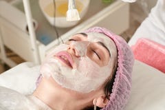 Молодая женщина в салоне красоты делает применение moisturizing, размягчать стоковая фотография rf Молодая женщина в салоне красоты делает применение moisturizing, размягчать стоковая фотография rf