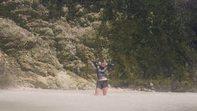 Молодая женщина во влажных одеждах наслаждаясь пропуская водопадом в положении женщины тропического леса счастливом под брызгать видеоматериал Молодая женщина во влажных одеждах наслаждаясь пропуская водопадом в положении женщины тропического леса счастливом под брызгать видеоматериал