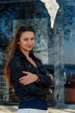 Молодая женщина идя на улицу Черная кожаная куртка стоковая фотография Молодая женщина идя на улицу Черная кожаная куртка стоковая фотография