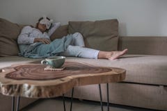Молодая женщина имеет остатки на бежевом кресле стоковое изображение Молодая женщина имеет остатки на бежевом кресле стоковое изображение