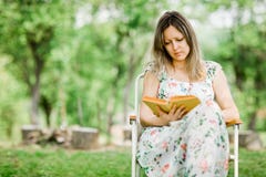Молодая женщина книга чтения на открытом воздухе в саде стоковые фото Молодая женщина книга чтения на открытом воздухе в саде стоковые фото