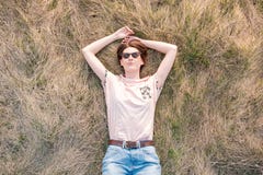 Молодая женщина на траве наслаждаясь весной стоковое фото Молодая женщина на траве наслаждаясь весной стоковое фото