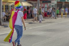 Молодая женщина нося верхнюю часть гордости горячую и прогулку накидк стоковое изображение Молодая женщина нося верхнюю часть гордости горячую и прогулку накидк стоковое изображение