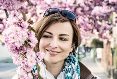 Молодая женщина представляя с цвести дерево Сакуры, голубой фильтр Стоковое Фото Молодая женщина представляя с цвести дерево Сакуры, голубой фильтр Стоковое Фото