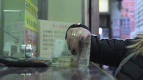 Молодая женщина принимая наличные деньги денег от перемещения промежутка времени окна обмена валюты в городе Гонконга, Китае Тури видеоматериал Молодая женщина принимая наличные деньги денег от перемещения промежутка времени окна обмена валюты в городе Гонконга, Китае Тури видеоматериал