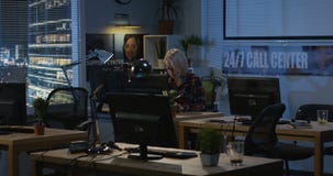 Молодая женщина работая вечером в офисе Молодая женщина работая вечером в офисе