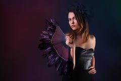 Молодая женщина с черными вентилятором и шляпой пера стоковые фото Молодая женщина с черными вентилятором и шляпой пера стоковые фото