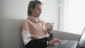 Молодая женщина сидя на кресле работая на компьютере Молодая женщина сидя на кресле работая на компьютере