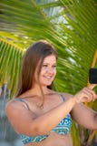 Молодая женщина со смартфоном перед ладонью стоковая фотография rf Молодая женщина со смартфоном перед ладонью стоковая фотография rf