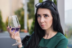 Молодая женщина со стеклом фиолетового коктейля дальше сидит на летней террасе ресторана стоковое фото rf Молодая женщина со стеклом фиолетового коктейля дальше сидит на летней террасе ресторана стоковое фото rf