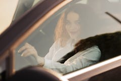 Молодая женщина управляя автомобилем в городе Портрет красивой бизнес-леди в автомобиле r стоковая фотография Молодая женщина управляя автомобилем в городе Портрет красивой бизнес-леди в автомобиле r стоковая фотография