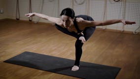 Молодая и милая женщина в костюме спорт стоит на одной ноге и делает протягивающ тренировки стоя на циновке акции видеоматериалы Молодая и милая женщина в костюме спорт стоит на одной ноге и делает протягивающ тренировки стоя на циновке акции видеоматериалы