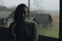 Молодая красивая девушка в деревне Модель на предпосылке деревянного дома в деревне темный свет стоковое фото Молодая красивая девушка в деревне Модель на предпосылке деревянного дома в деревне темный свет стоковое фото