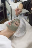 Молодая красивая девушка в зеленой маске для стороны ослабляя в салоне курорта стоковые изображения rf Молодая красивая девушка в зеленой маске для стороны ослабляя в салоне курорта стоковые изображения rf