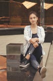 Молодая красивая девушка сидит на улице Подкрашиванное фото стоковые фотографии rf Молодая красивая девушка сидит на улице Подкрашиванное фото стоковые фотографии rf