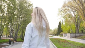 Молодая красивая женщина в солнечных очках Милая блондинка на прогулке ( видеоматериал Молодая красивая женщина в солнечных очках Милая блондинка на прогулке ( видеоматериал