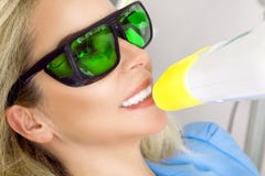 Молодая красивая женщина при красивые белые зубы сидя на зубоврачебном стуле стоковые фотографии rf Молодая красивая женщина при красивые белые зубы сидя на зубоврачебном стуле стоковые фотографии rf