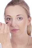 Молодая красивейшая женщина прикладывая concealer на стороне стоковая фотография Молодая красивейшая женщина прикладывая concealer на стороне стоковая фотография