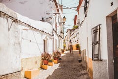 Молодая модная женщина брюнета идя вниз с улицы одного в Elvas, Португалии стоковые изображения Молодая модная женщина брюнета идя вниз с улицы одного в Elvas, Португалии стоковые изображения
