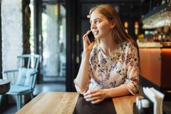 Молодая очаровательная девушка говоря на телефоне сидя самостоятельно в кафе в ее свободном временени, привлекательной женщине пр стоковые фото Молодая очаровательная девушка говоря на телефоне сидя самостоятельно в кафе в ее свободном временени, привлекательной женщине пр стоковые фото