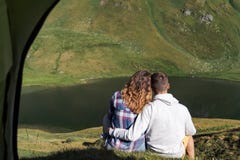 Молодая пара обнимает один другого перед шатром в горах Швейцарии стоковое фото Молодая пара обнимает один другого перед шатром в горах Швейцарии стоковое фото