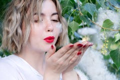 Молодая привлекательная freckled девушка дует приполюсный пушок, красные губы стоковая фотография rf Молодая привлекательная freckled девушка дует приполюсный пушок, красные губы стоковая фотография rf