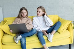 Молодая привлекательная дама дела 2 в случайных одеждах сидя совместно на желтой софе стоковые фотографии rf Молодая привлекательная дама дела 2 в случайных одеждах сидя совместно на желтой софе стоковые фотографии rf