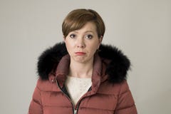 Молодая сладостная и унылая красная женщина волос представляя унылый и подавленный смотреть к камере нося теплую куртку пальто зи стоковое фото Молодая сладостная и унылая красная женщина волос представляя унылый и подавленный смотреть к камере нося теплую куртку пальто зи стоковое фото
