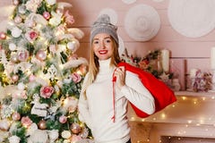 Молодая усмехаясь женщина с подарками красными сумки для рождества стоковая фотография rf Молодая усмехаясь женщина с подарками красными сумки для рождества стоковая фотография rf