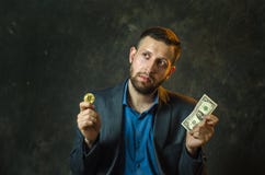 Молодой бизнесмен держит монетку bitcoite в его руке стоковые изображения rf Молодой бизнесмен держит монетку bitcoite в его руке стоковые изображения rf
