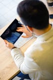 Молодой бизнесмен используя планшет пока работающ в современной кофейне стоковые изображения rf Молодой бизнесмен используя планшет пока работающ в современной кофейне стоковые изображения rf