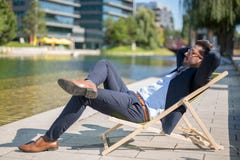 Молодой бизнесмен наслаждаясь его перерывом на sunbed перед офисом стоковые фото Молодой бизнесмен наслаждаясь его перерывом на sunbed перед офисом стоковые фото