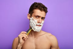 Молодой внушительный человек с раздражанным выражением, смотрит серьезно на камере стоковое фото rf Молодой внушительный человек с раздражанным выражением, смотрит серьезно на камере стоковое фото rf