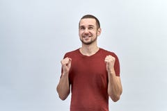 Молодой красивый парень, человек в красной рубашке держит перед им обхватил в кулаки руки стоковые фото Молодой красивый парень, человек в красной рубашке держит перед им обхватил в кулаки руки стоковые фото