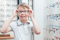 Молодой мальчик быть очень счастливый с его новыми eyeglasses в магазине стоковое фото Молодой мальчик быть очень счастливый с его новыми eyeglasses в магазине стоковое фото